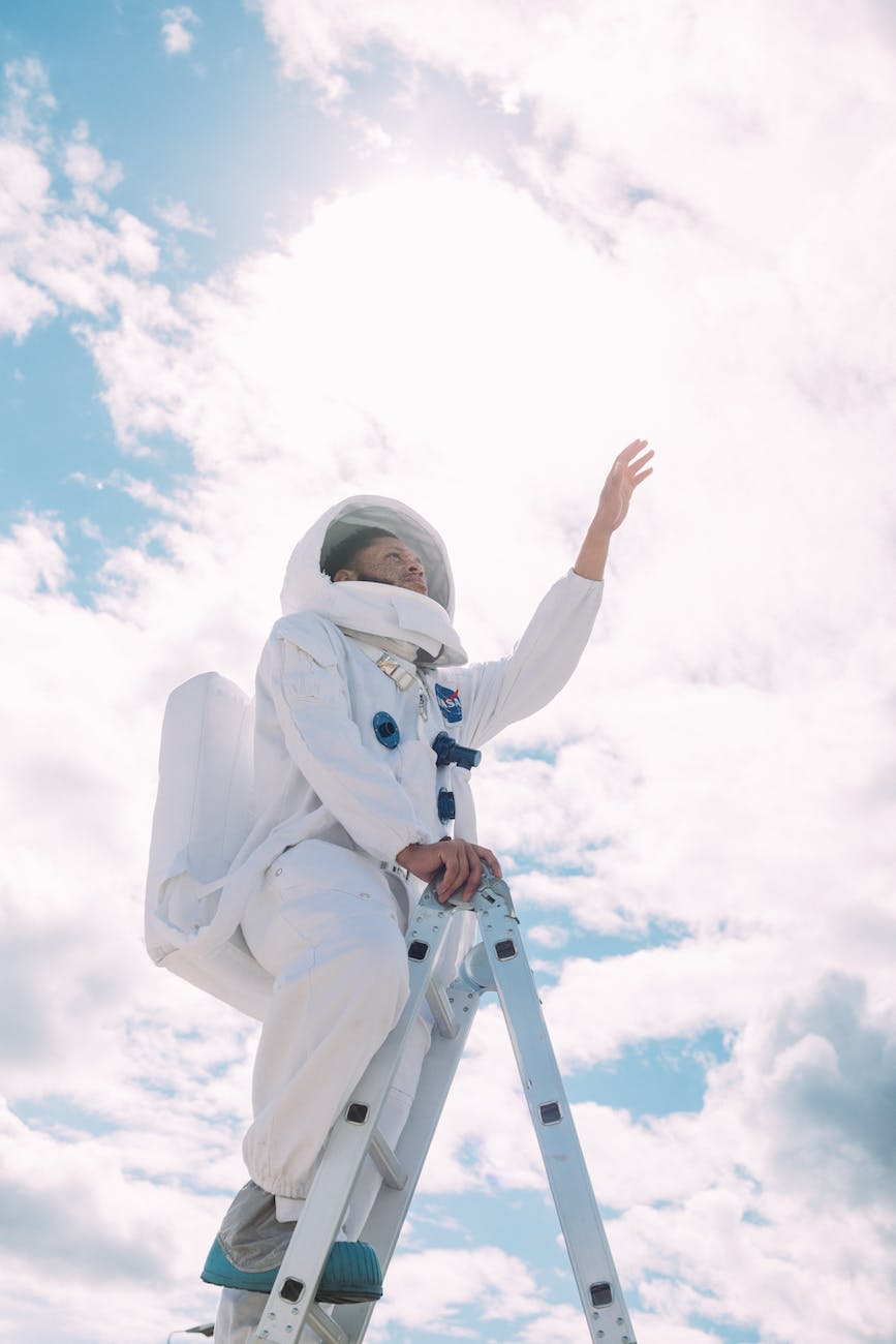 man in an astronaut costume going up a ladder